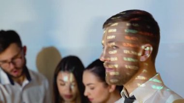 Smiling confident businessman leader looking at camera standing in office at team meeting. Male company executive professional manager posing with cryptocurrency chart on background