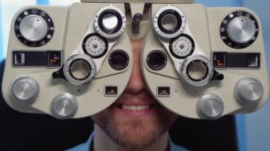 Patient in ophthalmology clinic. Handsome young man is checking the eye vision in modern ophthalmology clinic.