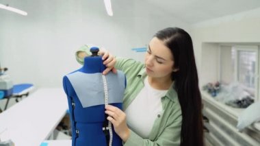 Female dressmaker attach fabric to mannequin. Creating dress design. Tailor industry concept