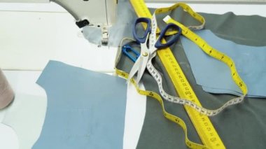 Threads, pattern, scissors, tape measure, and a sewing machine. Workplace of seamstress. Tailor industry concept