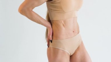 Close up of young woman demonstrating flat stomach