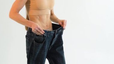 Woman in oversize jeans after weight loss. Diet concept