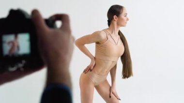 The photographer takes a photo to a young sports girl