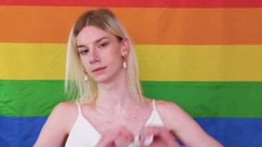 Smiling gay man with pride flag. Gender fluid man against lgbt flag.