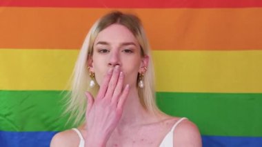 Smiling gay man wi.th pride flag. Gender fluid man against lgbt flag