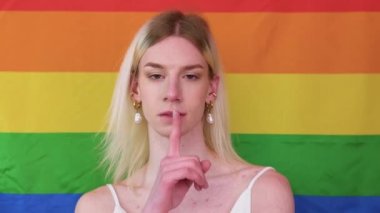 Smiling gay man with pride flag. Gender fluid man against lgbt flag.