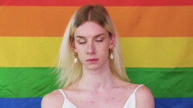 Smiling gay man with pride flag. Gender fluid man holding a lgbt flag against white background.