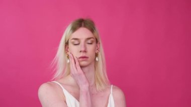 Portrait close up of young transgender man smile. Sensual blond male in casual crop top