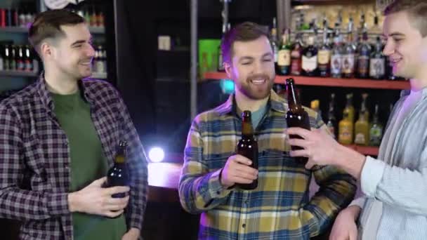 Handsome Friends Clinking Bottles Beer Smiling While Resting Pub — Stockvideo