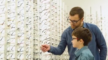 Family buy glasses. Father in a blue shirt.
