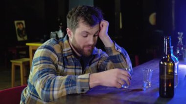 Bir adam bardaklara ve içkilere alkol doldurur. alkolizm kavramı