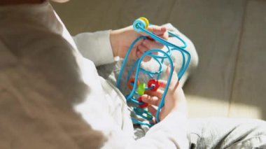 Little boy playing education logical toy on the floor in nursery.