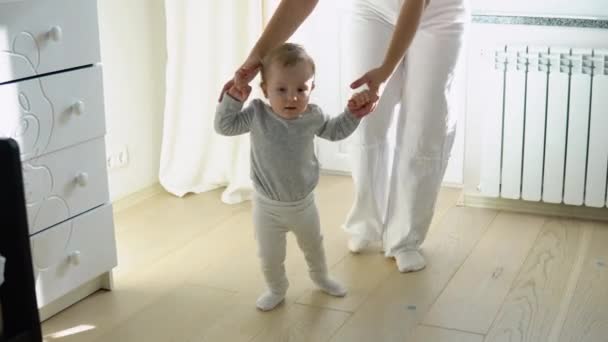 Bebê Dando Primeiros Passos Com Mães Ajuda Casa — Vídeo de Stock
