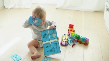 Cute baby girl playing with educational toy in nursery.