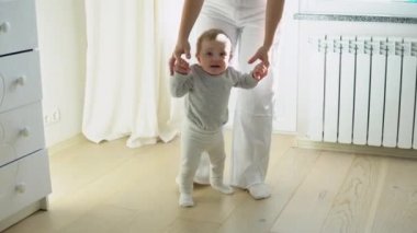 Evde anneler yardım ile ilk adımları atıyor Bebek.