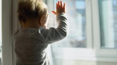 Gülümseyen bebek beyaz Oda evde pencere yanında ayakta.