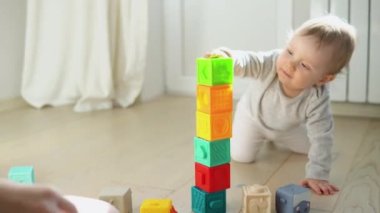 Çocuk renkli oyuncak bloklarıyla oynuyor. Çocuklar oynar. Bebek ve bebek için eğitici bir oyun