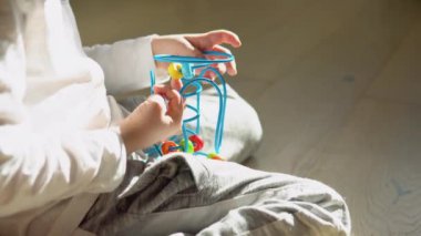 Little boy playing education logical toy on the floor in nursery.