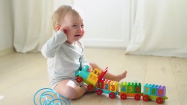 Child playing with toy colorful train.