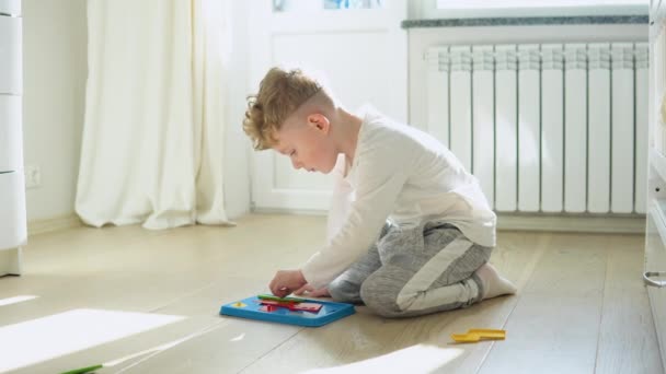 小男孩在幼儿园的地板上玩教育逻辑玩具 — 图库视频影像
