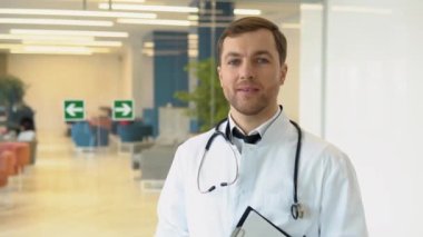 Male doctor standing in clinic in a hallway. Perfect medical service in hospital. Medicine and healthcare concept.