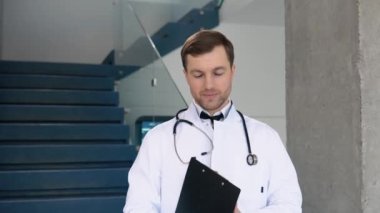 Male doctor standing in clinic in a hallway. Perfect medical service in hospital