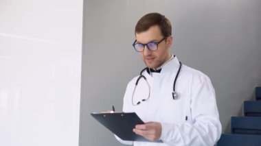 Beyaz üniformalı gülümseyen beyaz beyaz erkek doktorun profil fotoğrafı hastanede iyi hizmet verdiğini gösteriyor. Klinikteki mutlu pratisyen hekimin ya da çocuk doktorunun portresi. Sağlık hizmetleri kavramı.