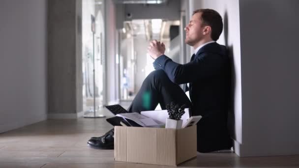 解雇箱でオフィスの近くの廊下で不満と動揺に座って解雇されたビジネスマンや従業員 仕事を失った — ストック動画