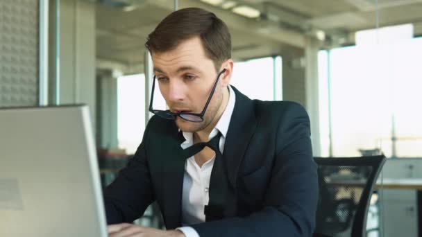 疲れ若い実業家眼鏡を取る眼ひずみの概念頭痛疲労オフィスコンピュータの仕事の後にデスクに座る — ストック動画
