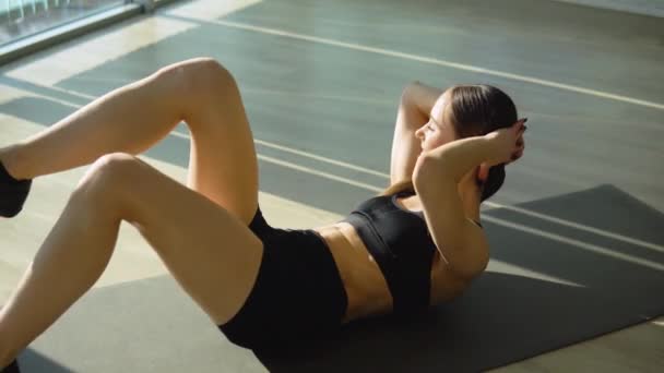 从事健身锻炼的女性 在健身俱乐部做腹肌锻炼的积极的女职业健身教练 — 图库视频影像