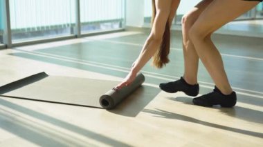 Woman roll out yoga mat for preparation. Close up view on hand when open mat. Young beautiful fit sport woman work out by exercise yoga in living room