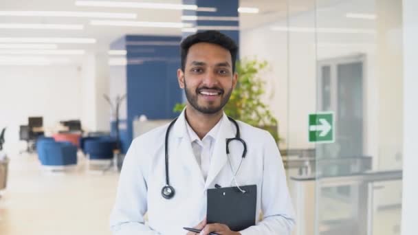 Determined Indian Pakistani Handsome Doctor Wearing White Coat Stethoscope Walks — Stockvideo