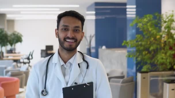 Determined Indian Pakistani Handsome Doctor Wearing White Coat Stethoscope Walks — 비디오