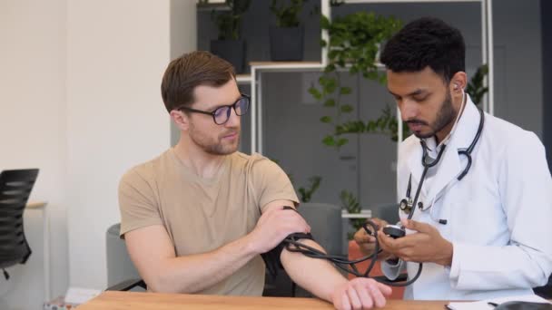 Indian Doctor Holding Dial While Measuring Mans Blood Pressure — Wideo stockowe