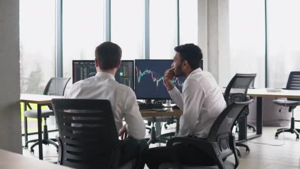 Two Men Traders Sitting Desk Office Together Monitoring Stocks Data — Vídeo de Stock
