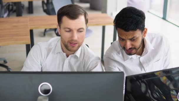 オフィスのデスクに座っている2人の男性トレーダー一緒に株式データキャンドルチャートのマネーフローを監視画面に集中したチームワーク戦略の概念を議論 — ストック動画