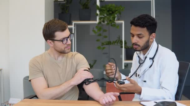 Indian Doctor Holding Dial While Measuring Mans Blood Pressure Hypertension — Wideo stockowe
