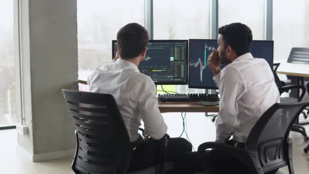 Two Men Traders Sitting Desk Office Together Monitoring Stocks Data — Video