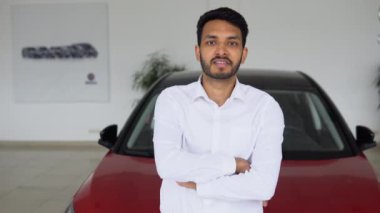 Portrait of happy adult successful man posing in auto showroom buying new automobile