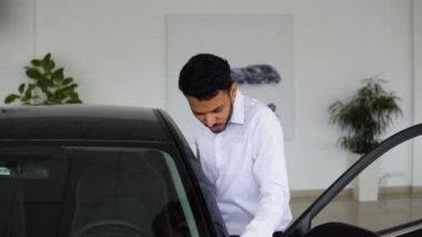 Indian man examines his new car. Auto business, car sale, technologies and peoples concept