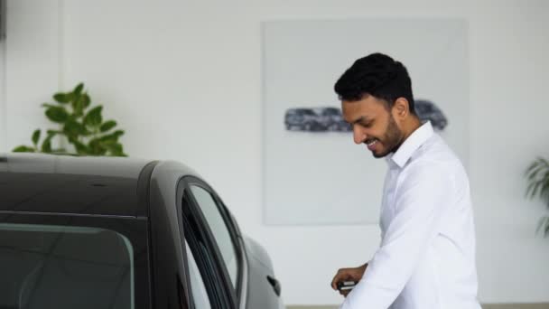 快乐的印度人站在新豪华轿车旁的经销商处 英俊的小伙子选择了交通工具去买东西 汽车商业概念 — 图库视频影像