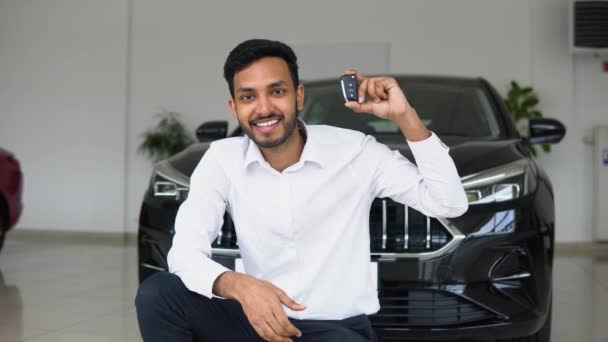 Positive Pakistani Male Smiling Camera Demonstrating Keys While Sitting New — Stockvideo