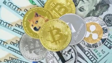 Bitcoin BTC, Ethereum ETH, Ripple XRP, Litecoin LTC, Dogecoin DOGE coins are rotating on bills of 100 dollars. Digital coin cyberspace and cryptocurrency. Concept of exchange market and online payment