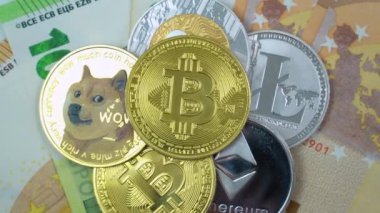 Bitcoin BTC, Ethereum ETH, Ripple XRP, Litecoin LTC, Dogecoin DOGE coins are rotating on bills of 50 and 100 euro. Concept of exchange market and online payment.