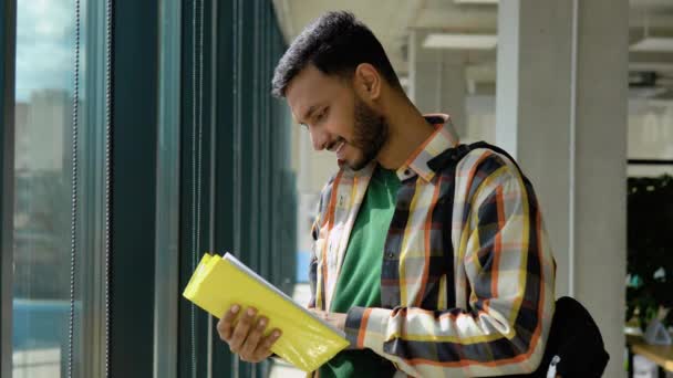Portret Indyjskiego Mądrego Ucznia Otwartą Książką Czytającego Bibliotece Uczelni — Wideo stockowe