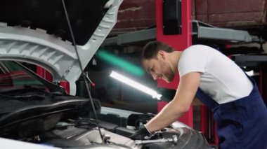 Araba Servisi, tamir, bakım ve insan kavramı - otomatik mekanik adam atölyesinde çalışan lambalı.