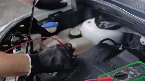 기술자는 자동차 배터리의 수준을 확인하기 측정기를 서비스 배터리 — 비디오
