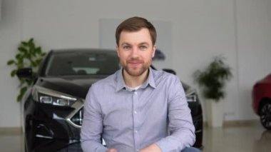 Anahtarı olan mutlu adam bir araba galerisinden yeni bir araba almaktan memnun.