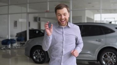 Komik adam bir araba galerisinde yürüyüp dans ediyor. Mutlu araba sahibi yeni bir araba almaktan memnun. Araba işi.