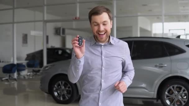 Αστείος Άνθρωπος Περπατάει Και Χορεύει Μια Αντιπροσωπεία Αυτοκινήτων Ευτυχής Ιδιοκτήτης — Αρχείο Βίντεο